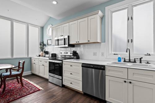 a kitchen with white cabinets and a sink at The Audrey - Springfield in Springfield