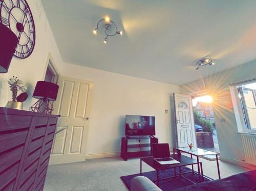 a living room with a couch and a tv at Reading Getaway For Families & Business & Parking in Earley
