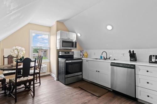 a kitchen with white cabinets and a table and a microwave at The Audrey - Springfield in Springfield
