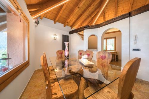 a dining room with a glass table and chairs at Casa Monica Ledro Attico in Mezzolago