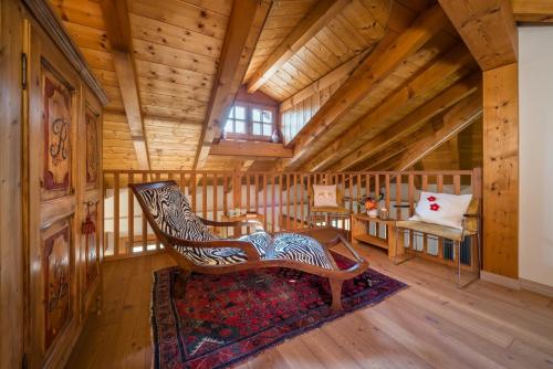 a room with a rocking chair in a log cabin at Casa Monica Ledro Attico in Mezzolago