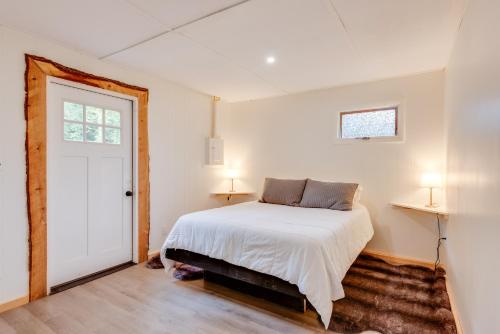 a bedroom with a white bed and a window at Pet-Friendly Cabin with Grill in Hillsgrove in Hillsgrove
