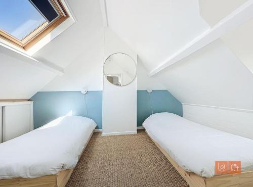 Un dormitorio abuhardillado con dos camas y una ventana. en Cap Blanc-Nez - 6 personnes - animaux acceptés, en Escalles