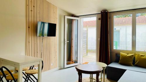 a living room with a couch and a table at Petite maison en bord de mer in Longeville-sur-Mer