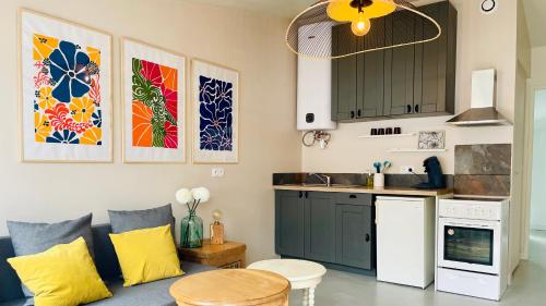 a living room with a couch and a kitchen at Petite maison en bord de mer in Longeville-sur-Mer