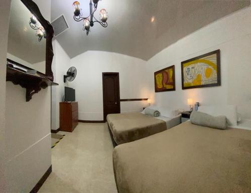 a bedroom with two beds and a chandelier at Hospedaje Camino Real a 150 MTS del centro in Salento