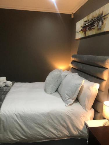 a bedroom with a bed with white sheets and pillows at Cass Villa 25 Kimberley in Kimberley