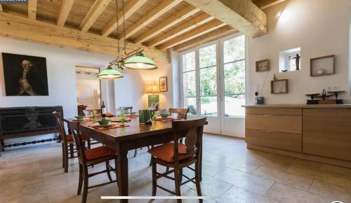 une cuisine et une salle à manger avec une table et des chaises dans l'établissement Superbe Longère, à Fourquevaux