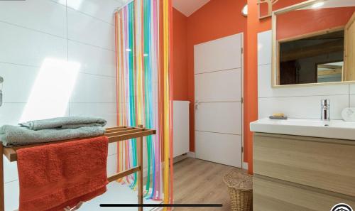 La salle de bains est pourvue d'un rideau de douche arc-en-ciel à côté d'un lavabo. dans l'établissement Superbe Longère, à Fourquevaux
