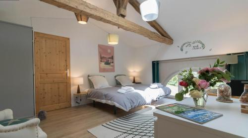 - une chambre avec 2 lits et un bureau orné de fleurs dans l'établissement Superbe Longère, à Fourquevaux