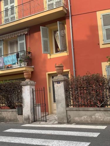 un bâtiment orange avec une porte et une clôture dans l'établissement Bilocale a trenta metri dal mare, à Roquebrune-Cap-Martin