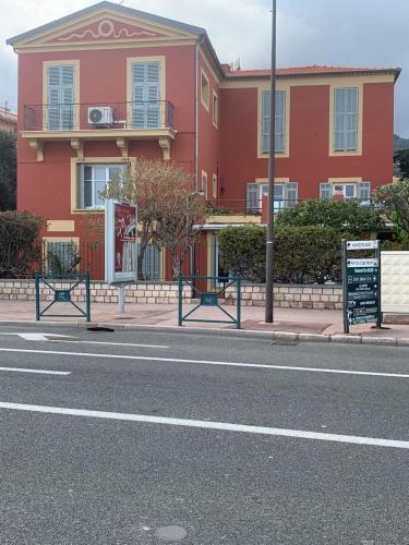 un bâtiment rouge sur le côté d'une rue dans l'établissement Bilocale a trenta metri dal mare, à Roquebrune-Cap-Martin