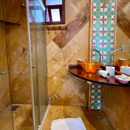 a bathroom with a shower and a wooden sink at Pousada Fortal Villa Praia in Fortaleza