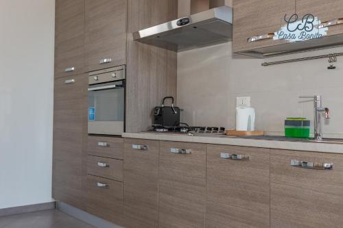a kitchen with wooden cabinets and a stove top oven at Casa Bonita Rho in Rho