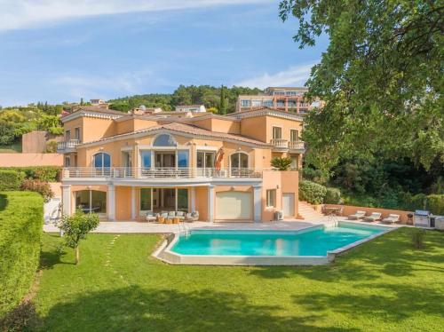 une grande maison avec une piscine dans la cour dans l'établissement Logement entier villa de luxe avec vue mer, à Théoule-sur-Mer