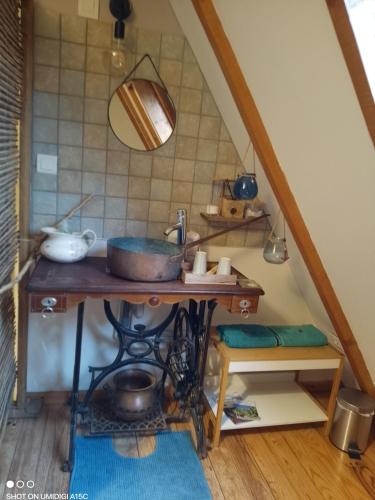 - une cuisine mansardée avec une table et un évier dans l'établissement Gîtes du GRC, à Campuac