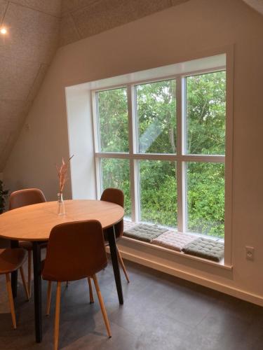 a dining room with a table and a large window at Varde Bed and Kitchen in Varde