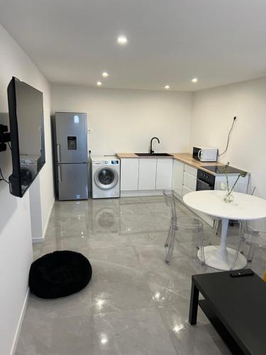 La cuisine est équipée d'un réfrigérateur, d'une table et d'un évier. dans l'établissement Type 2 moderne neuf, à Marseille