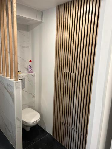 une salle de bain avec toilettes et porte en bois dans l'établissement Type 2 moderne neuf, à Marseille