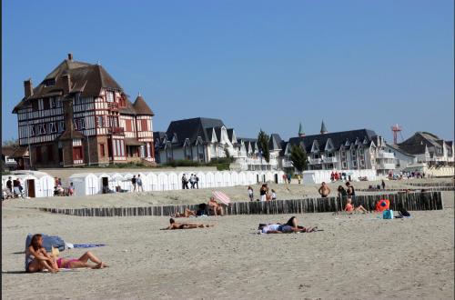 a group of people laying on the beach at Aux Passagers de la baie 2 in Le Crotoy