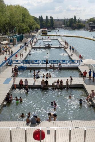 un groupe de personnes dans l'eau d'une piscine dans l'établissement Olympic Parc La Villette PARIS 19 Cosy Studio, à Paris