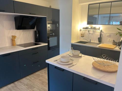 une cuisine avec des placards bleus et un comptoir blanc dans l'établissement Style Industriel élégant, proche vieille ville, à Annecy