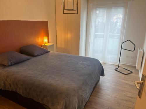 une chambre avec un grand lit et une fenêtre dans l'établissement Style Industriel élégant, proche vieille ville, à Annecy