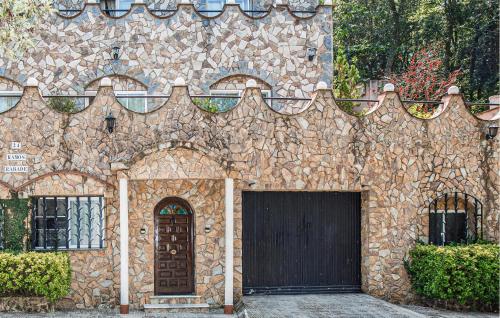 a stone building with a door and a gate at 2 Bedroom Cozy Apartment In Vidreres in Vidreres
