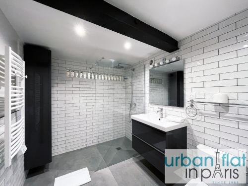 une salle de bain blanche avec un lavabo et un miroir dans l'établissement Urban Flat 161 - Sublime Luxury Flat in Paris, à Paris