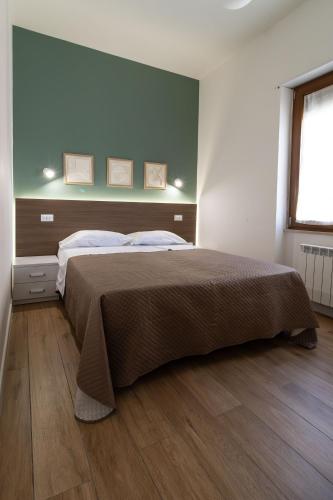 a bedroom with a bed and a green wall at B&B Sila in Fiore in San Giovanni in Fiore