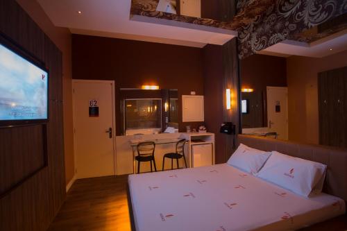 a bedroom with a bed and a kitchen with a bar at Audace Motel in Porto Alegre