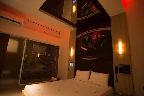 a bedroom with a bed and a painting on the wall at Audace Motel in Porto Alegre