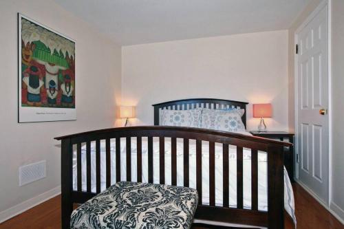 a bedroom with a crib with two lamps and a painting at Niagara SkyLine Park And Walk To The Falls & Wonderful Free Breakfast Deliverd Daily to the Rental in Niagara Falls