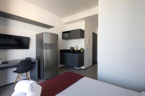 a room with a bed and a kitchen with a refrigerator at 360 VN Turiassú by Housi in Sao Paulo