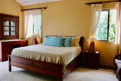a bedroom with a bed and two windows at Villa-Agapito GuavaberryJuanDolio-11Px-3BR-5Bds-WiFi-BBQ-PrivatePool in Los Conucos