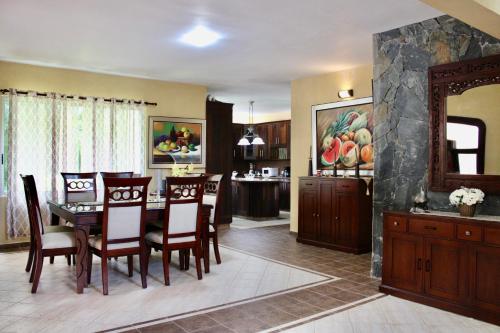 a kitchen and dining room with a table and chairs at Villa-Agapito GuavaberryJuanDolio-11Px-3BR-5Bds-WiFi-BBQ-PrivatePool in Los Conucos