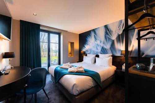 une chambre d'hôtel avec un lit et un bureau dans l'établissement Hôtel-SPA Le Moulin De La Wantzenau - Strasbourg Nord, à La Wantzenau