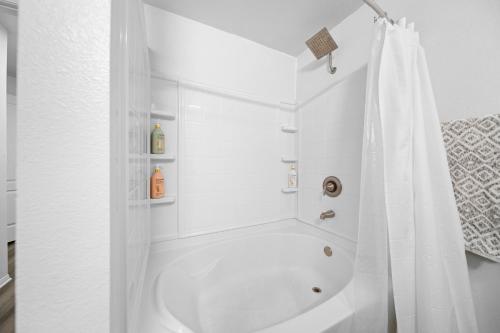 Un baño blanco con bañera y ducha. en Swim Dine Relax in Marina Del REY, en Los Ángeles