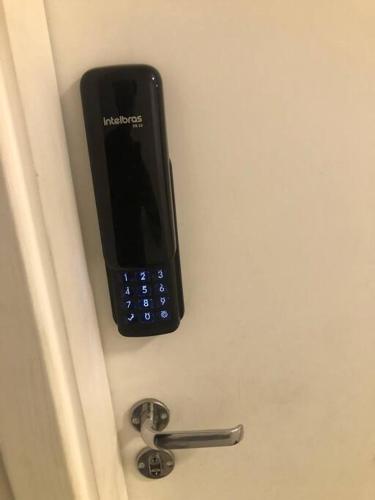 a cell phone is hanging on a door at 06 - Apto Studio Liberdade Sé 500'Metrô in Sao Paulo