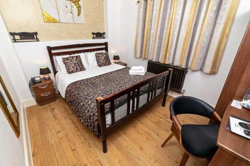 a bedroom with a bed and a desk and a chair at G Boutique Hotel in Portsmouth
