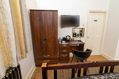 a room with a desk and a cabinet and a chair at G Boutique Hotel in Portsmouth
