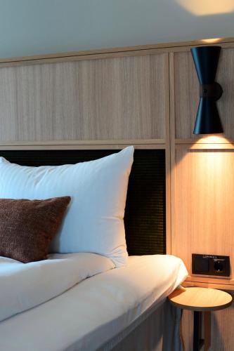 a bedroom with a bed with a lamp and a table at Quality Hotel Ålesund in Ålesund