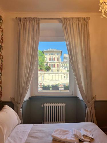 ein Bett in einem Schlafzimmer mit einem großen Fenster in der Unterkunft B&B Dimora Liberty in Genua