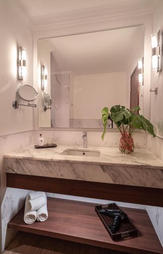 a bathroom with a sink and a large mirror at Hotel Saint George in Puerto Iguazú
