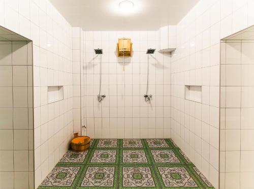 a bathroom with a toilet and a tiled floor at Azhur Hotel in Tambov