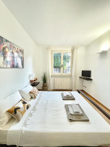 a large white bed in a room with a window at Casa Matilde piano terra 100mq con parking e piscina in Ferrara