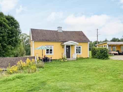 a yellow house with a lawn in front of it at 4 person holiday home in VIRSERUM in Virserum