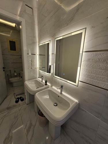 a white bathroom with a sink and a mirror at شقق جاذر ان السلمانية in As Sayl aş Şaghīr