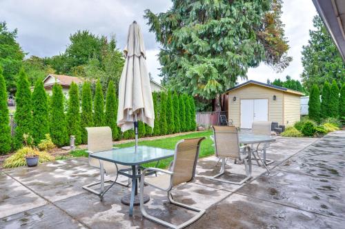 a patio with a table and an umbrella and chairs at Milwaukie Home with Outdoor Dining Space in Milwaukie