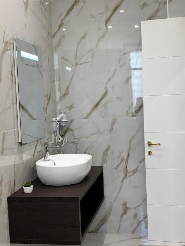a bathroom with a sink and a marble wall at A Casa di Nina Modern House in Pompei